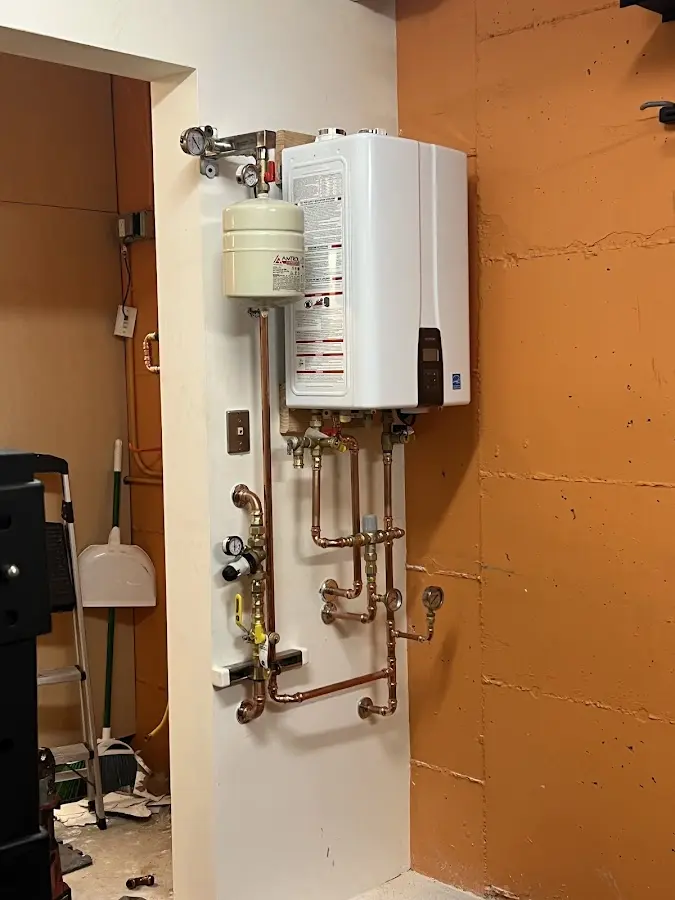 Plumbing technician inspecting water heater connections in Beverly